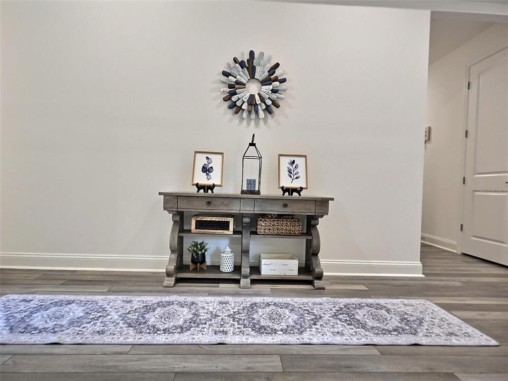 A console table with decor sits against a wall on wood-look flooring — 2 PAT PLACE, PALM COAST, FL