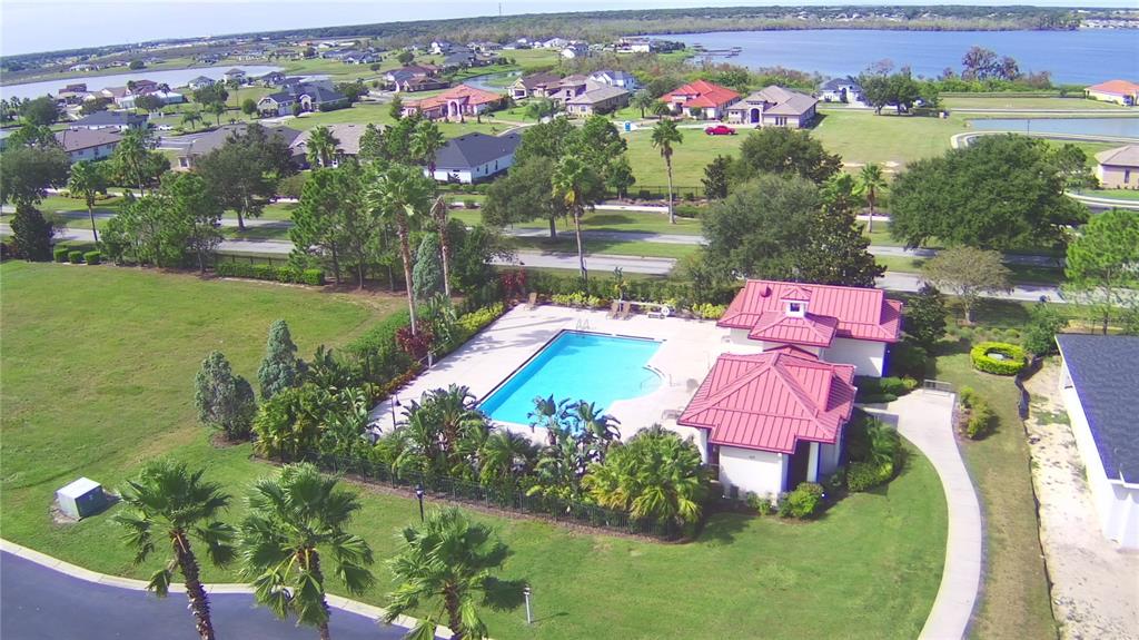 An aerial view shows a community swimming pool and clubhouse surrounded by landscaped grounds — 361 ADAMS VIEW LANE, AUBURNDALE, FL