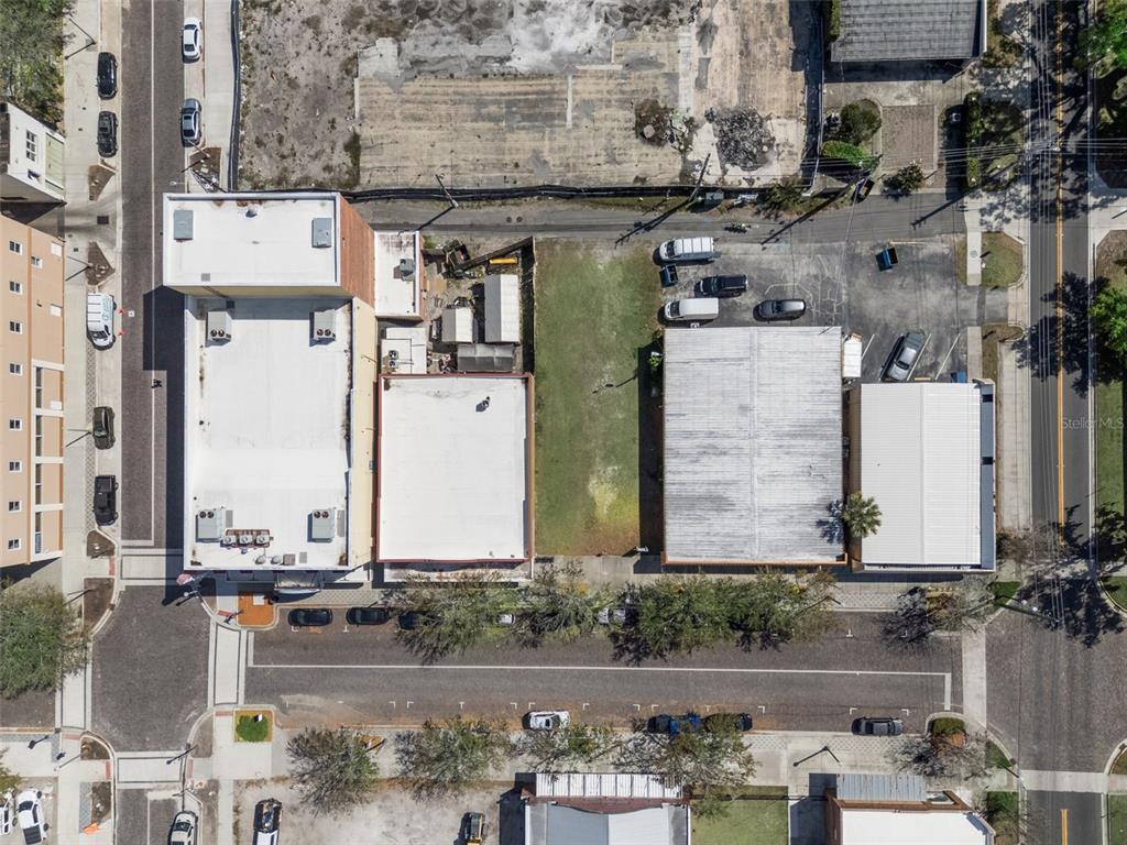 This aerial view shows several commercial buildings with flat roofs and adjacent parking lots — 215 MAGNOLIA AVENUE, SANFORD, FL