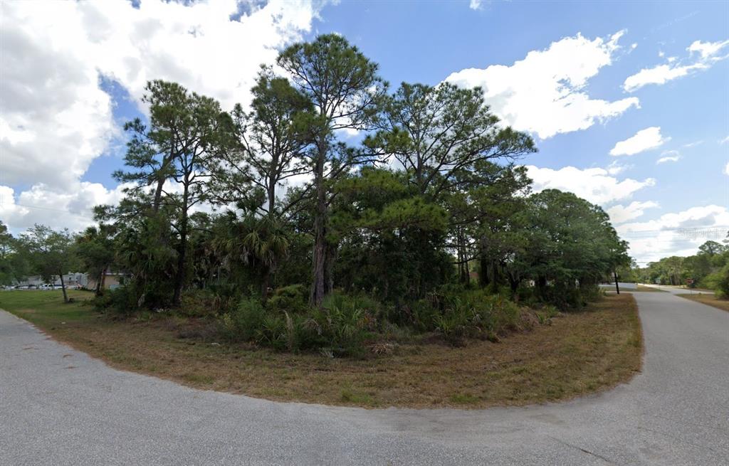A vacant, wooded corner lot features tall pine trees and low-lying palmetto shrubs — 17508 YORK AVENUE, PORT CHARLOTTE, FL