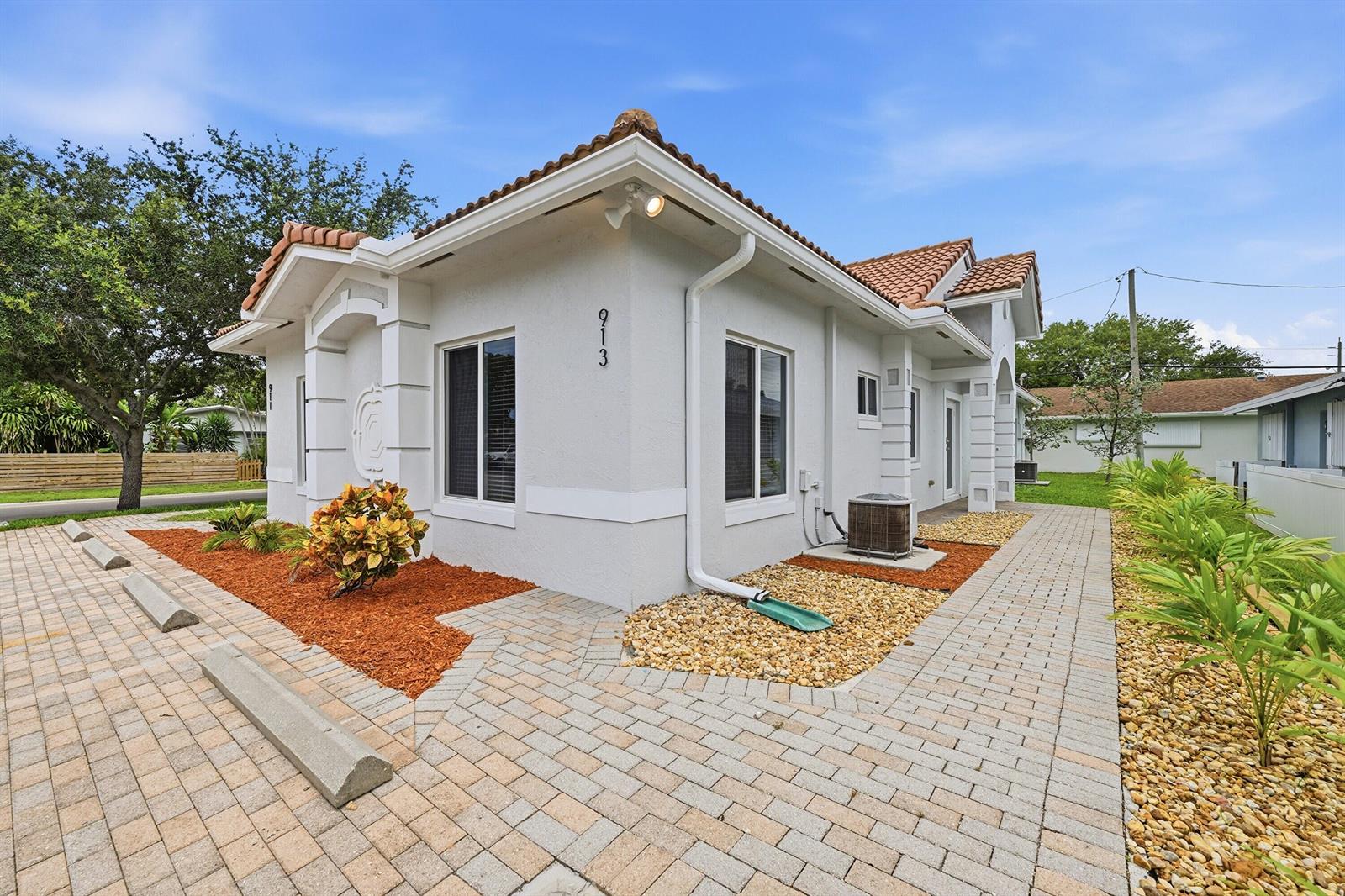 A white stucco building with a tiled roof and a paved walkway and parking area — 911 NE 12th Avenue, Pompano Beach FL 33060, POMPANO BEACH, FL