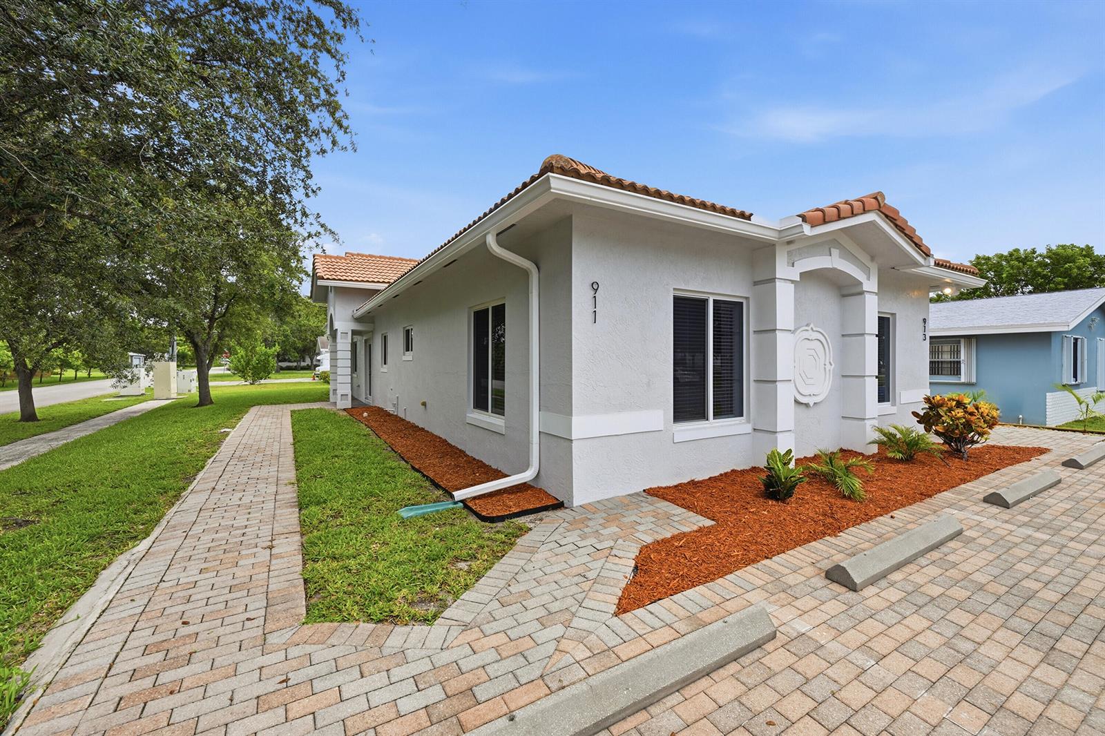 A light gray single-story building with a tiled roof and a brick paver parking area — 911 NE 12th Avenue, Pompano Beach FL 33060, POMPANO BEACH, FL