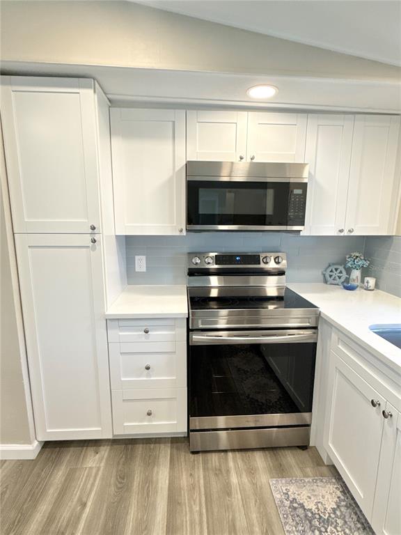 A kitchen features white cabinets, stainless steel appliances, and light-colored countertops — 217 MOUNT PINEY AVENUE NE UNIT 286, ST PETERSBURG, FL