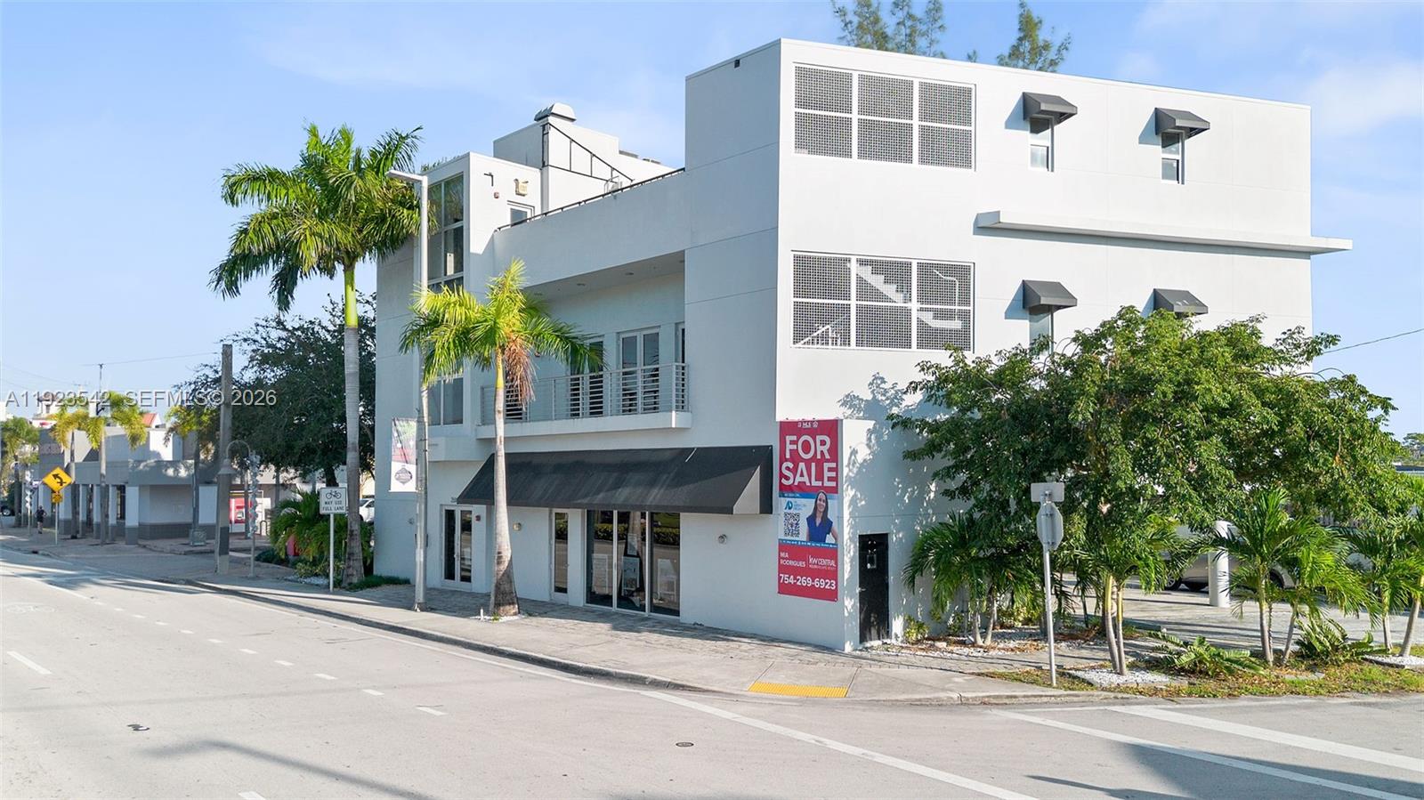 A three-story white commercial building with a black awning and a for sale sign — 2500 Wilton Dr, Wilton Manors FL 33305, WILTON MANORS, FL