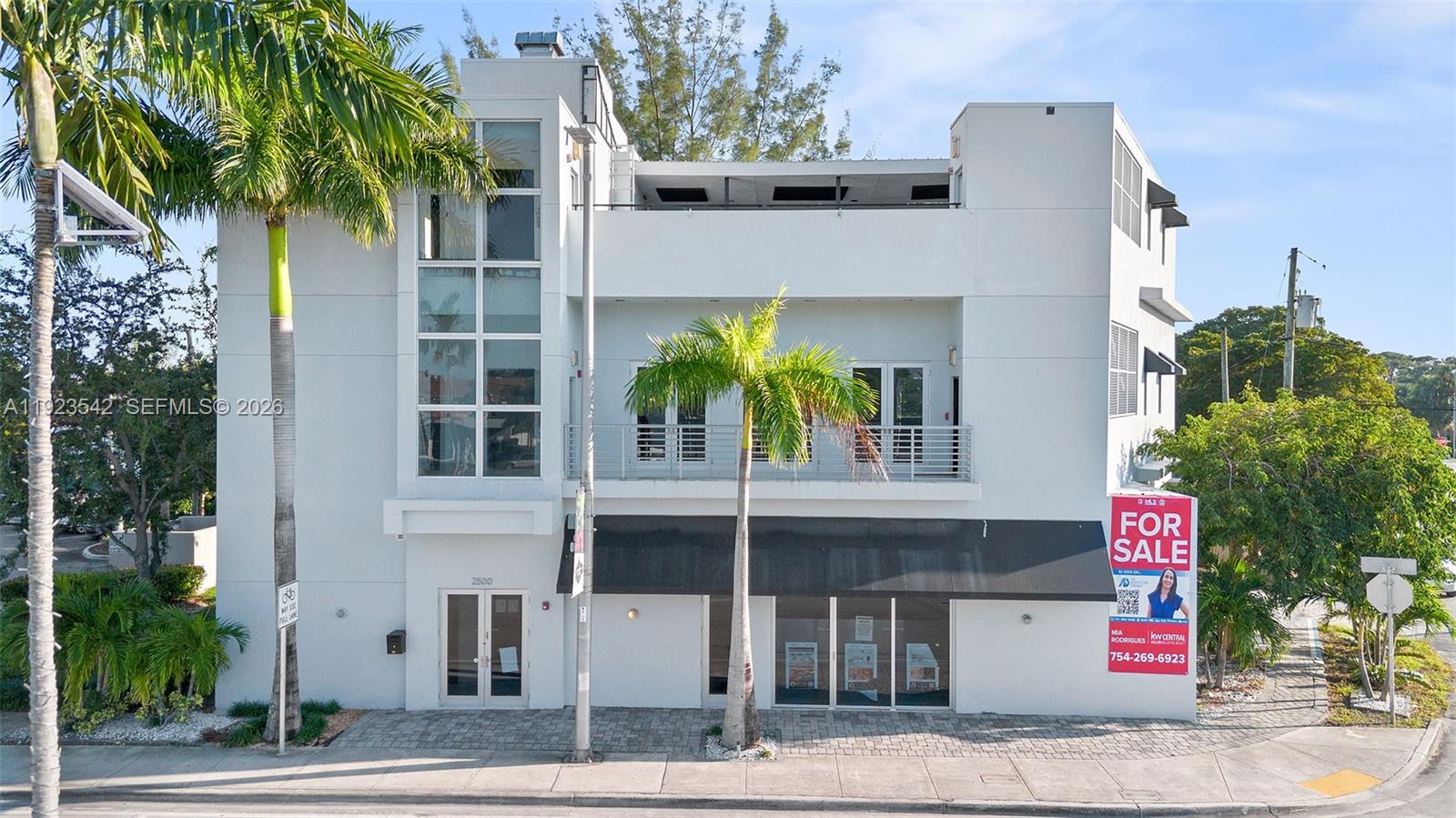 A three-story white commercial building features a glass stairwell, a balcony, and a black awning — 2500 Wilton Dr, Wilton Manors FL 33305, WILTON MANORS, FL
