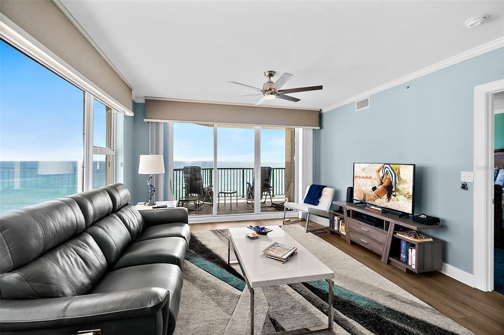 A living room features a leather sofa, a coffee table, and a balcony overlooking the ocean — 3315 S ATLANTIC AVENUE UNIT 1605, DAYTONA BEACH SHORES, FL