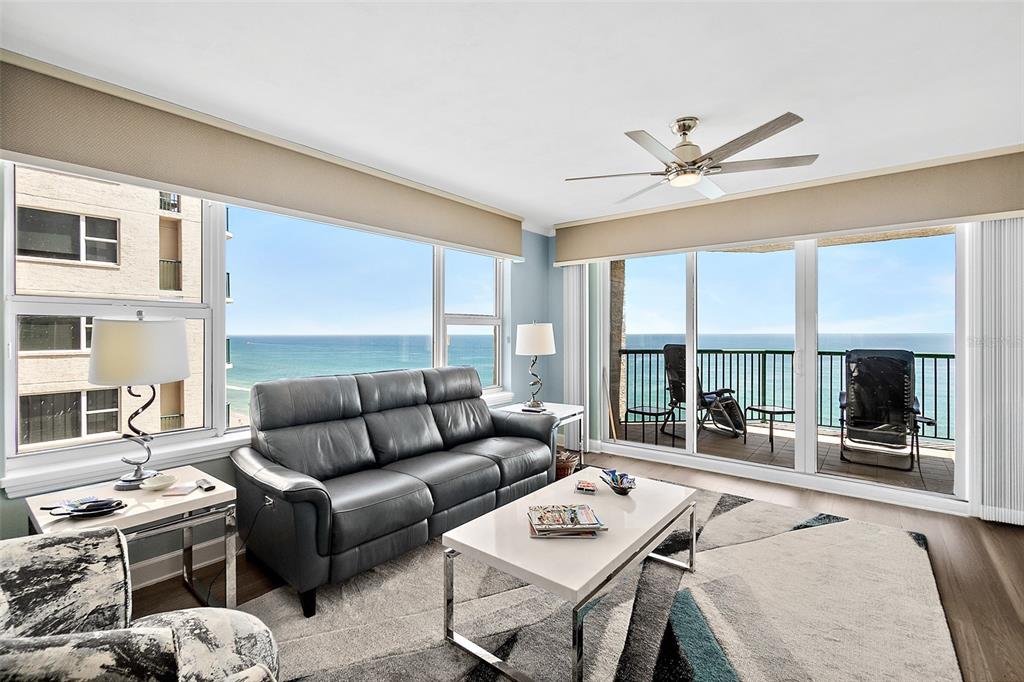 A living room features a leather sofa, a coffee table, and large windows overlooking the ocean — 3315 S ATLANTIC AVENUE UNIT 1605, DAYTONA BEACH SHORES, FL