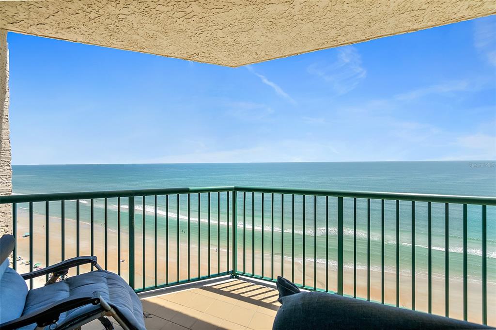 A balcony with a green metal railing overlooks a sandy beach and the ocean — 3315 S ATLANTIC AVENUE UNIT 1605, DAYTONA BEACH SHORES, FL