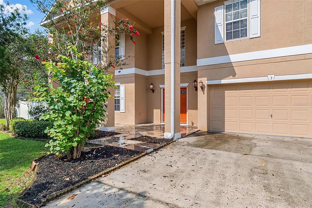 A two-story house exterior features a tan facade, a single-car garage, and a covered entryway — 3 ZORRO COURT, PALM COAST, FL