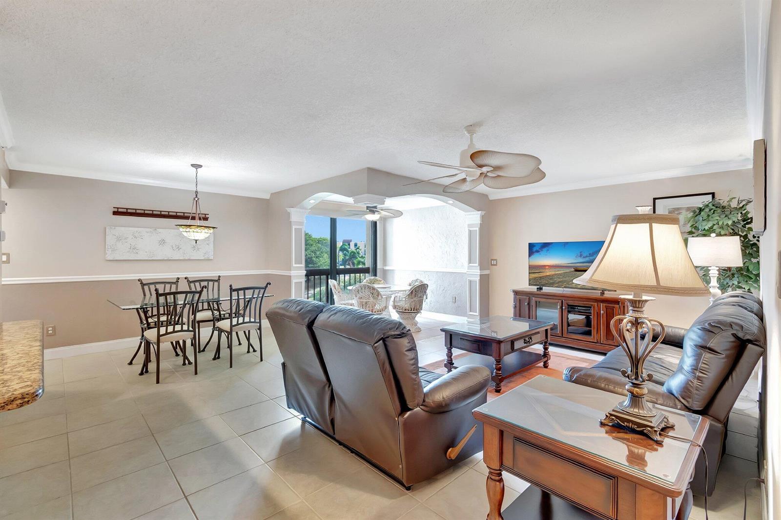 A living and dining area features tile floors, leather furniture, and a balcony with views — 1915 Lavers Circle # 303, Delray Beach FL 33444, DELRAY BEACH, FL