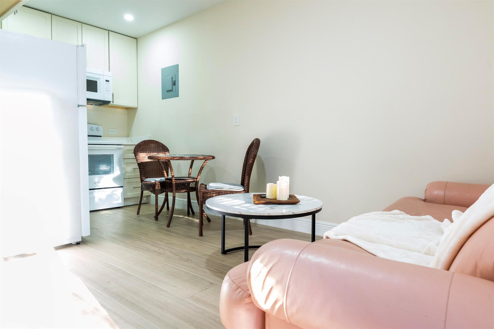 A small studio apartment features a kitchenette, a dining set, and a pink leather sofa — 13075 Marcella Boulevard Unit 2, FL 33470, FL