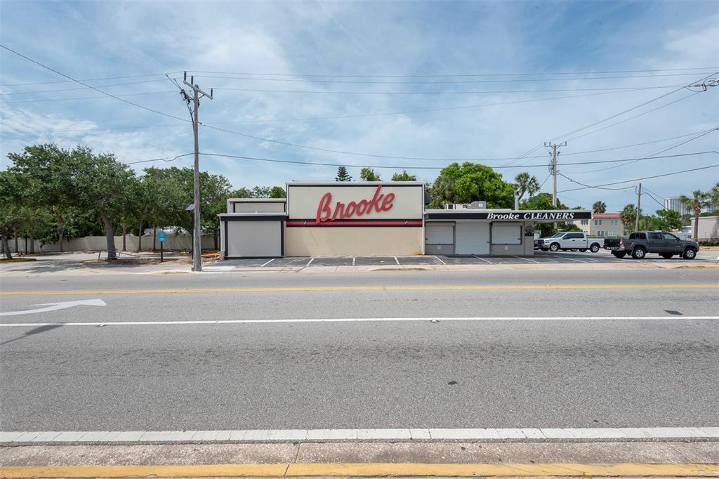 A single-story commercial building with a Brooke Cleaners sign stands beside a parking lot — 133 MAIN STREET E, DAYTONA BEACH, FL