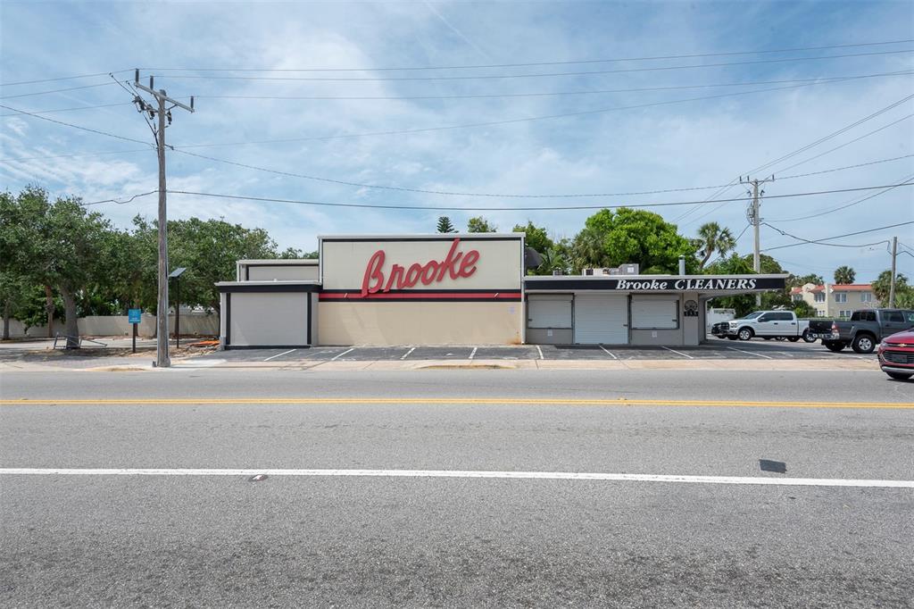 A commercial building with a Brooke Cleaners sign sits along a road with parking spaces — 133 MAIN STREET E, DAYTONA BEACH, FL