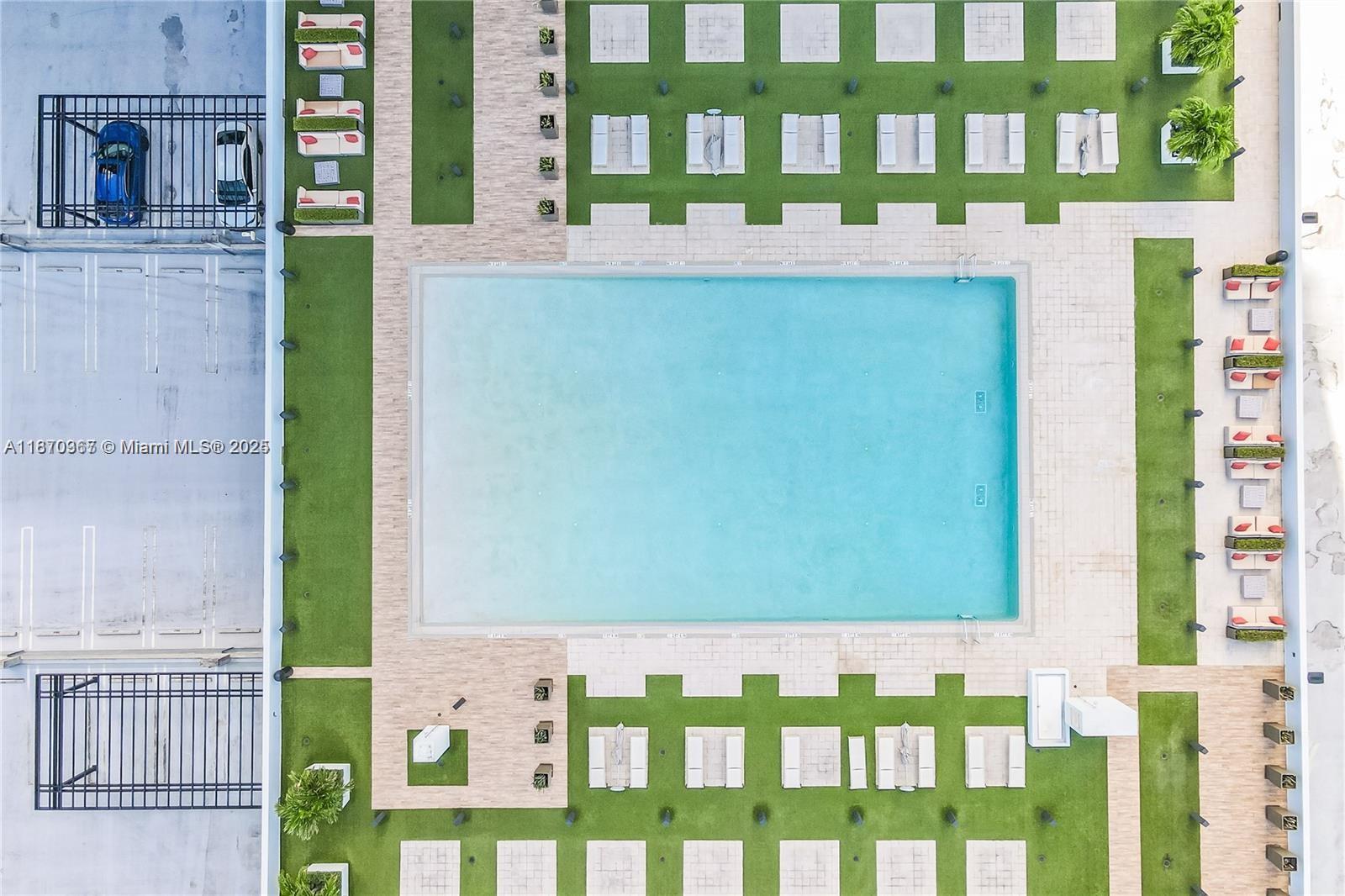 An aerial view shows a rectangular swimming pool surrounded by lounge chairs and green landscaping — 5252 NW 85th Ave # 1909, Doral FL 33166, DORAL, FL