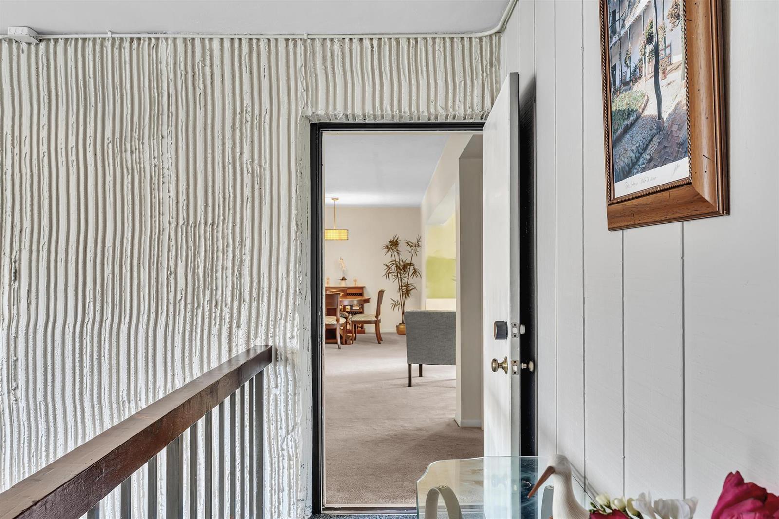 A doorway leads from a textured wall hallway into a carpeted dining and living area — 6561 Spring Bottom Way # 234, Boca Raton FL 33433, BOCA RATON, FL