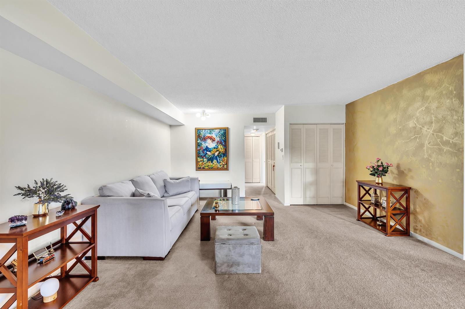 A living room features a grey sofa, a coffee table, and a gold-painted accent wall — 6561 Spring Bottom Way # 234, Boca Raton FL 33433, BOCA RATON, FL