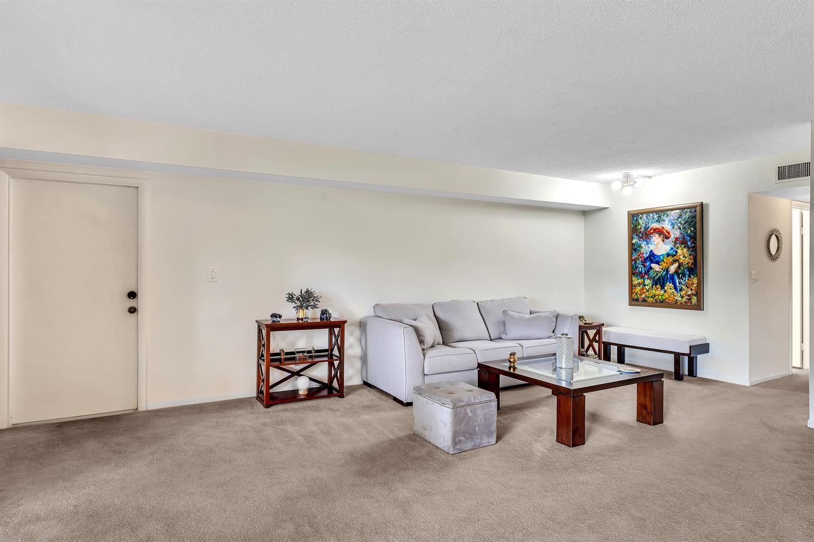 A living room features a light gray sofa, a glass-topped coffee table, and beige carpeting — 6561 Spring Bottom Way # 234, Boca Raton FL 33433, BOCA RATON, FL