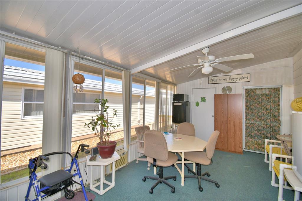 A sunroom features a dining table with chairs, a ceiling fan, and large windows — 4239 CEDARWOOD STREET, WINTER HAVEN, FL
