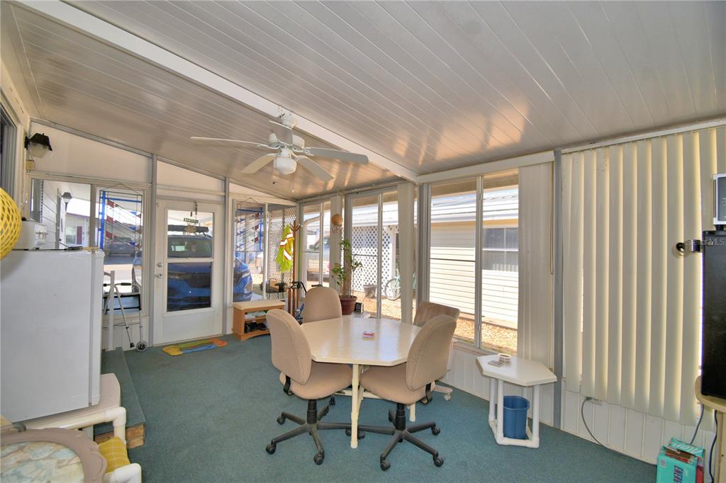 A sunroom features a dining table with chairs, a ceiling fan, and large glass windows — 4239 CEDARWOOD STREET, WINTER HAVEN, FL
