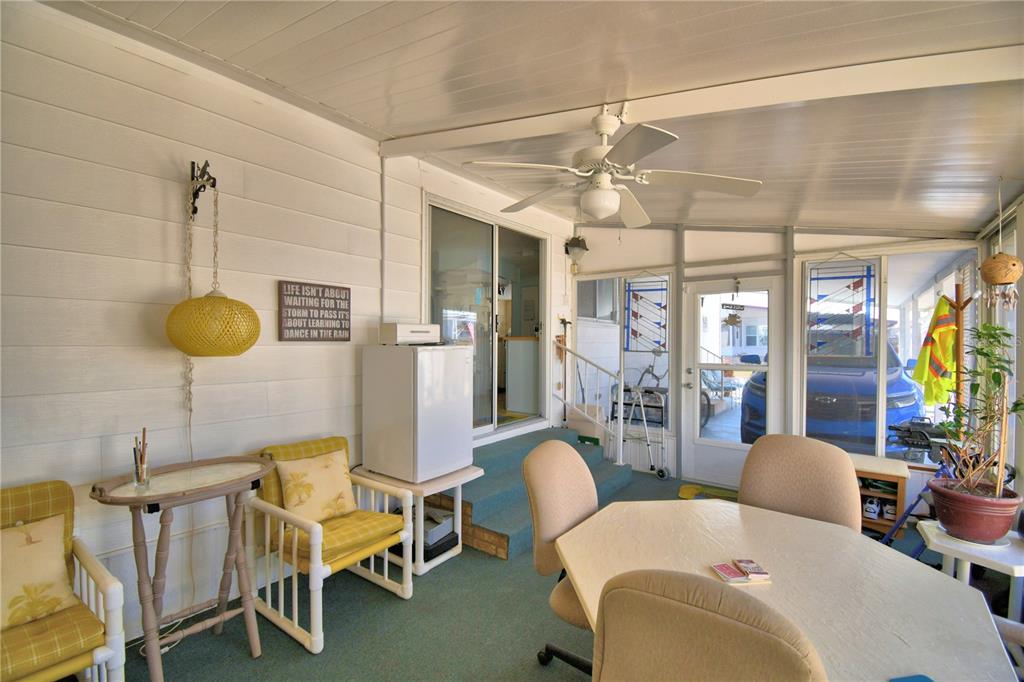 A sunroom features a ceiling fan, a dining table, chairs, and a small refrigerator — 4239 CEDARWOOD STREET, WINTER HAVEN, FL