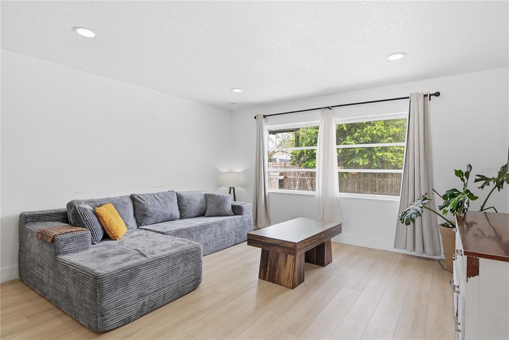 A living room features a gray sectional sofa, a wooden coffee table, and light wood flooring — 835 MARLOWE, ORLANDO, FL