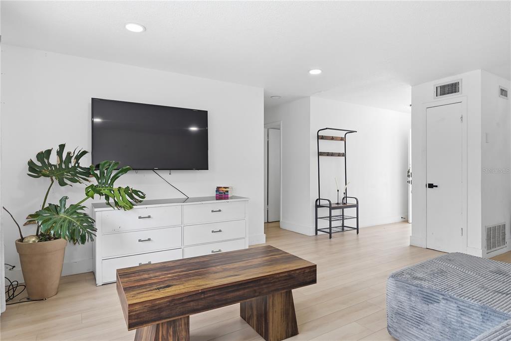 A living room features light wood flooring, white walls, a television, and a wooden coffee table — 835 MARLOWE, ORLANDO, FL