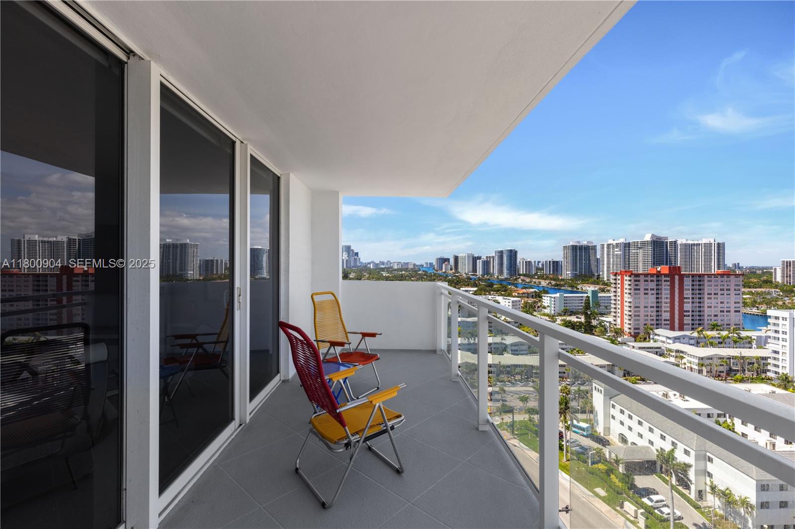 A balcony with two folding chairs overlooks a city skyline and a waterway — 2030 S Ocean Dr # 1707, Hallandale Beach FL 33009, HALLANDALE BEACH, FL