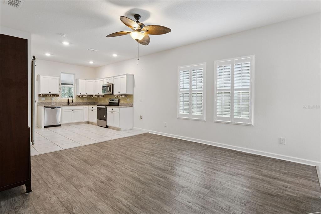 A room with wood-look flooring, a dark wood hutch, and two doorways leading to other rooms — 2059 CADES COVE WAY, DELAND, FL