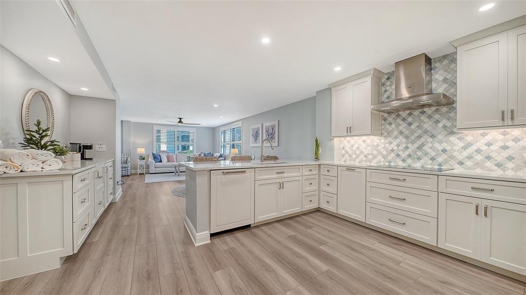 A modern kitchen with white cabinets, stainless steel appliances, and a patterned tile backsplash — 5780 MIDNIGHT PASS ROAD UNIT 110, SARASOTA, FL