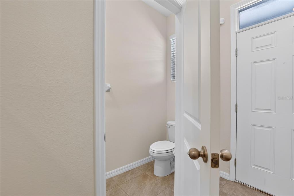 A view through an open doorway into a small bathroom with a toilet and tile flooring — 3816 SUNFLOWER FIELD PLACE, PLANT CITY, FL