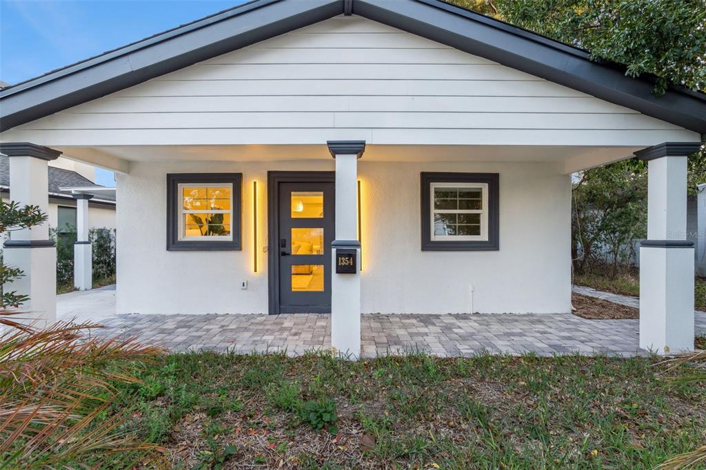 A white house with a gray front door, dark trim, and a paved front porch — 1354 INDIANA AVENUE, WINTER PARK, FL