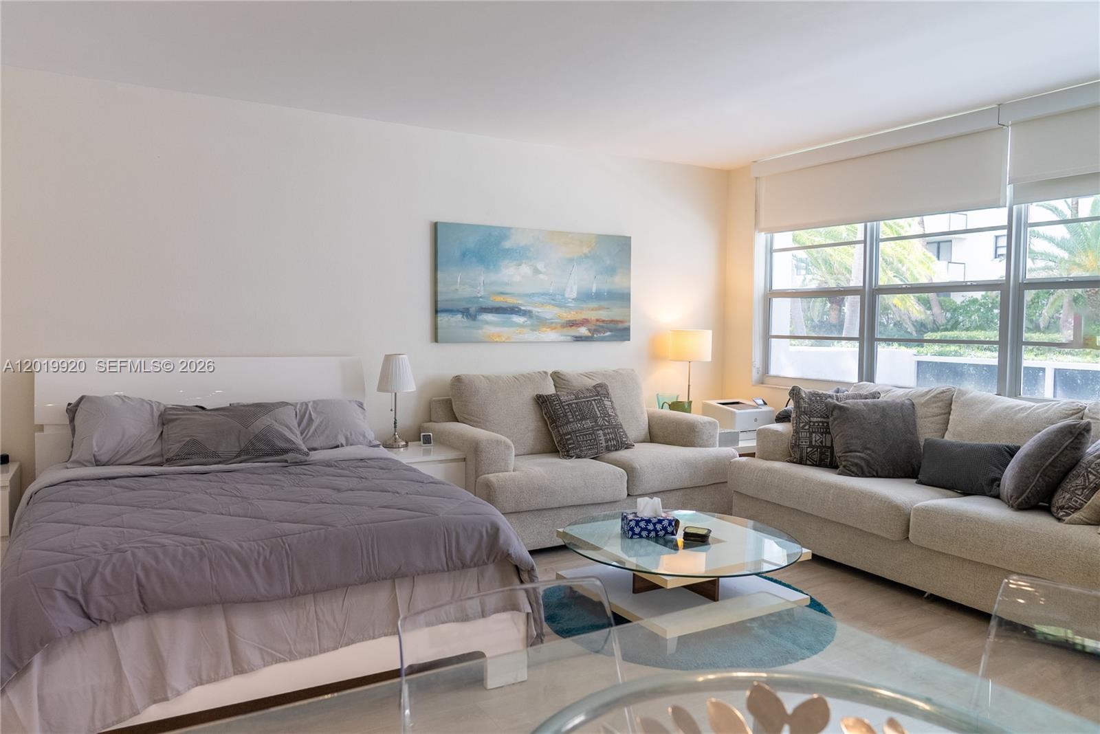 A studio apartment features a bed, two sofas, a glass coffee table, and large windows — 100 Lincoln Rd # 330, Miami Beach FL 33139, MIAMI BEACH, FL