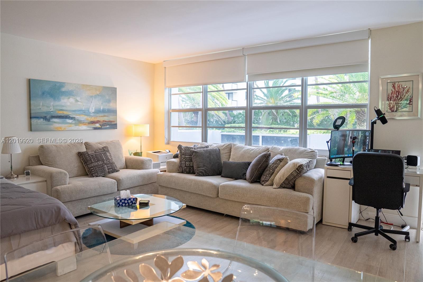 A living room features two beige sofas, a glass coffee table, and a home office area — 100 Lincoln Rd # 330, Miami Beach FL 33139, MIAMI BEACH, FL