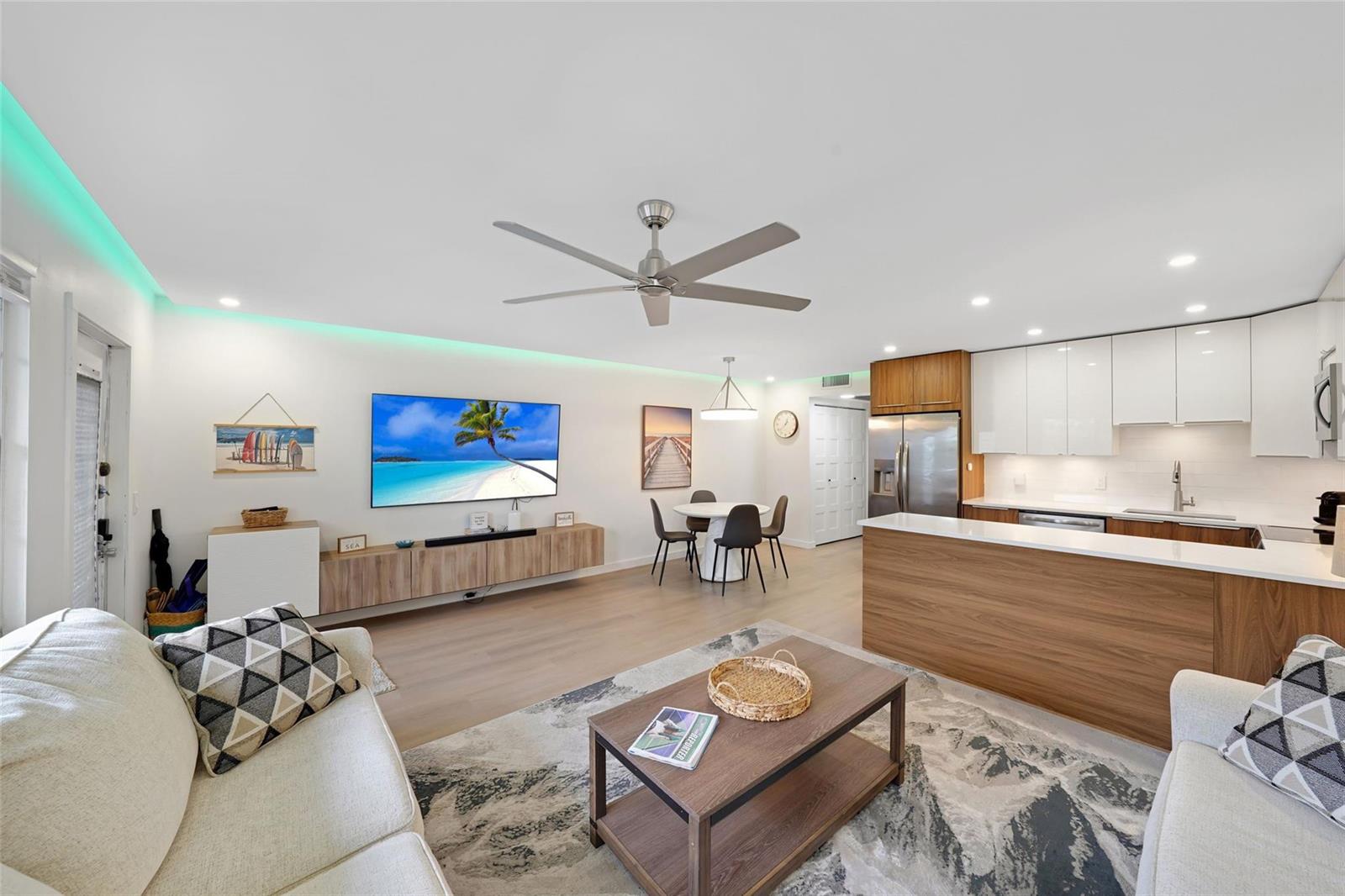 An open-concept living room and kitchen featuring light wood floors, modern cabinetry, and recessed lighting — 3034 Berkshire B # 3034, Deerfield Beach FL 33442, DEERFIELD BEACH, FL