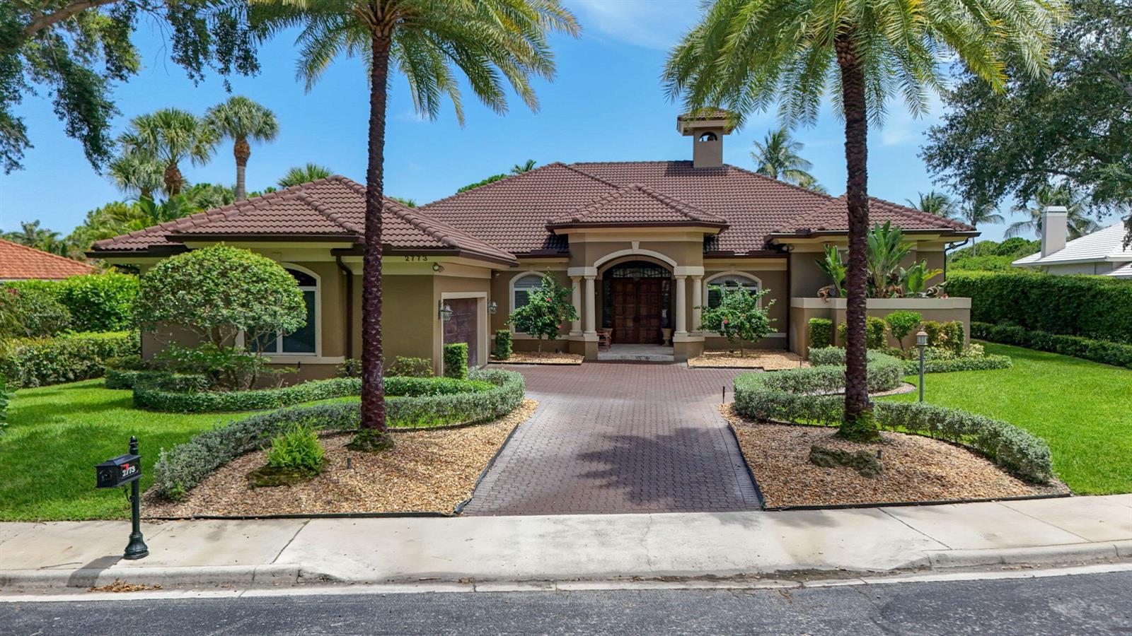 A single-story house with a brown tile roof, palm trees, and a brick-paved driveway — 2773 Tecumseh Drive, West Palm Beach FL 33409, WEST PALM BEACH, FL