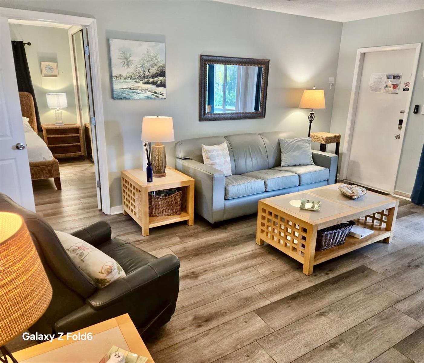 A living room features a gray sofa, a coffee table, and an adjacent bedroom doorway — 3225 NE 16th Street # 9A, Pompano Beach FL 33062, POMPANO BEACH, FL