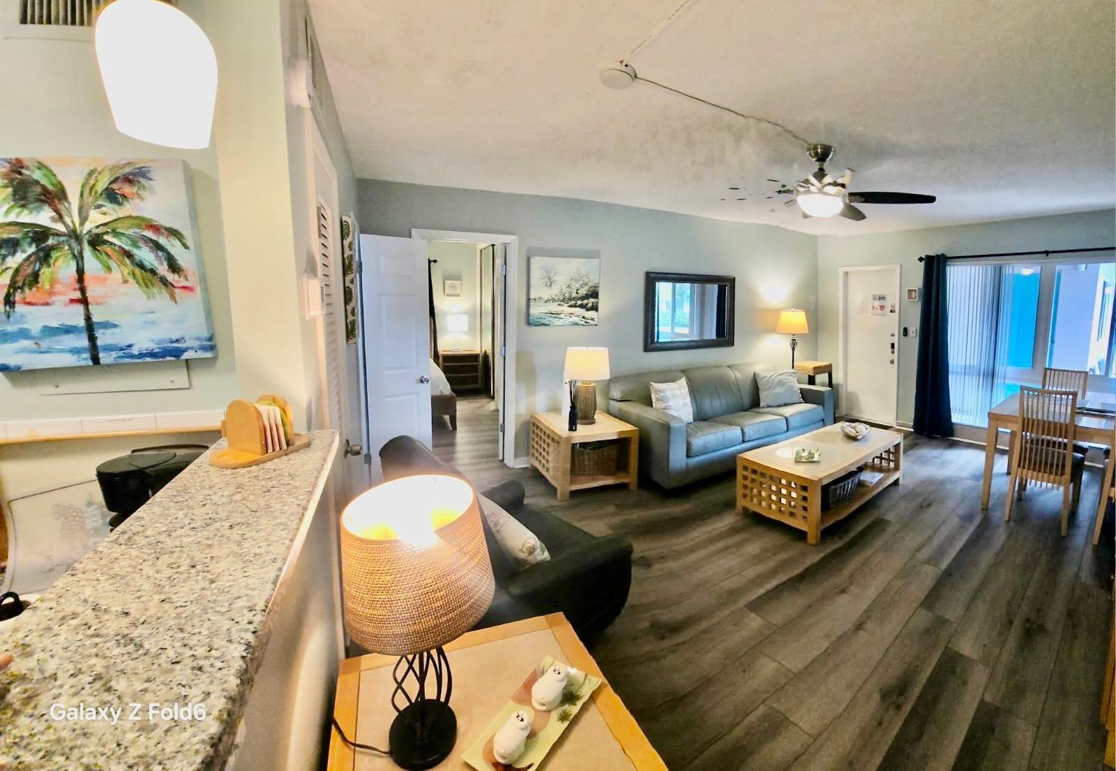 A living room with gray flooring, a leather sofa, a coffee table, and dining area — 3225 NE 16th Street # 9A, Pompano Beach FL 33062, POMPANO BEACH, FL