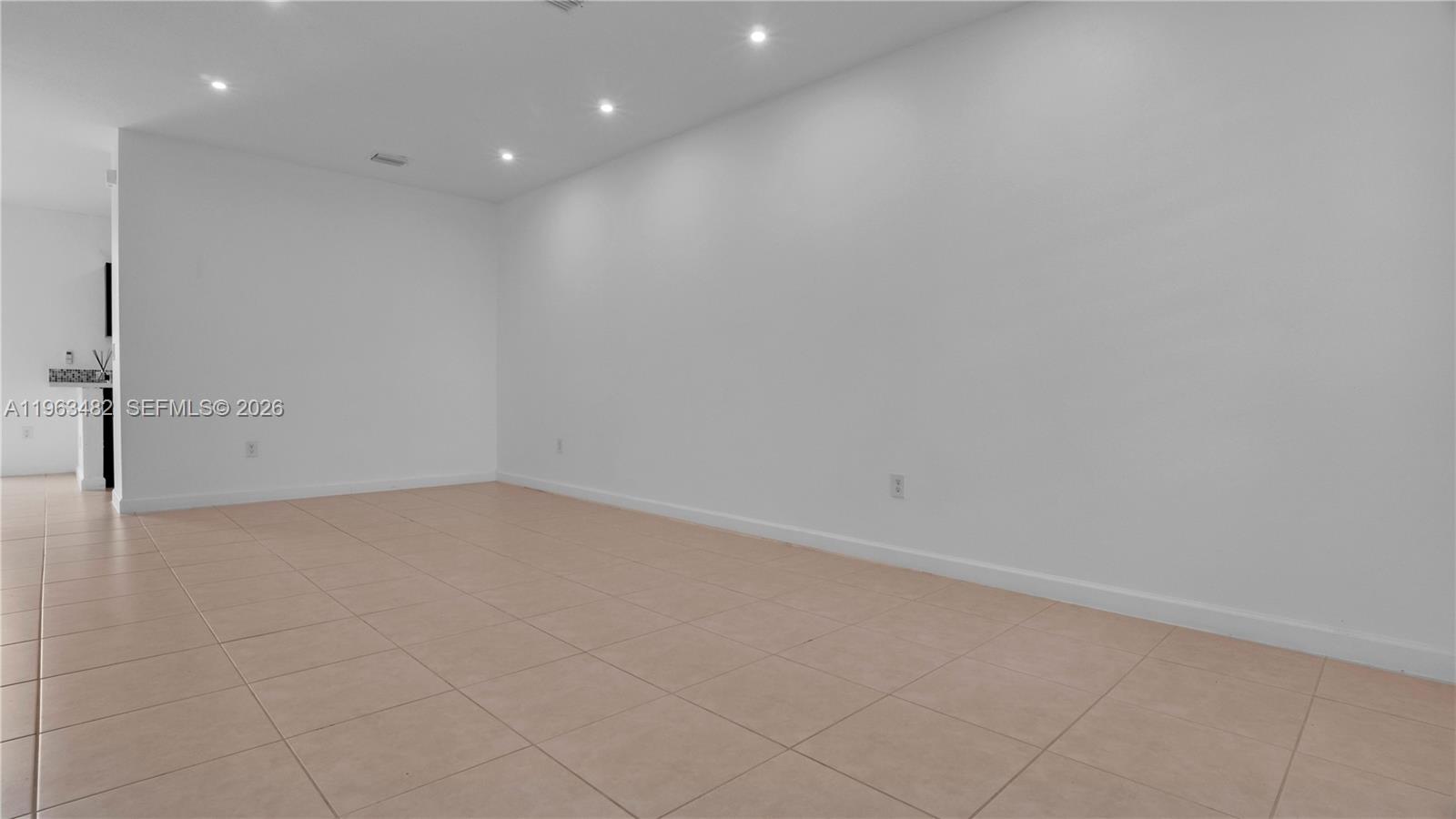 An empty room features white walls, recessed lighting, and light-colored square floor tiles — 8678 NW 113th Ct, Doral FL 33178, DORAL, FL