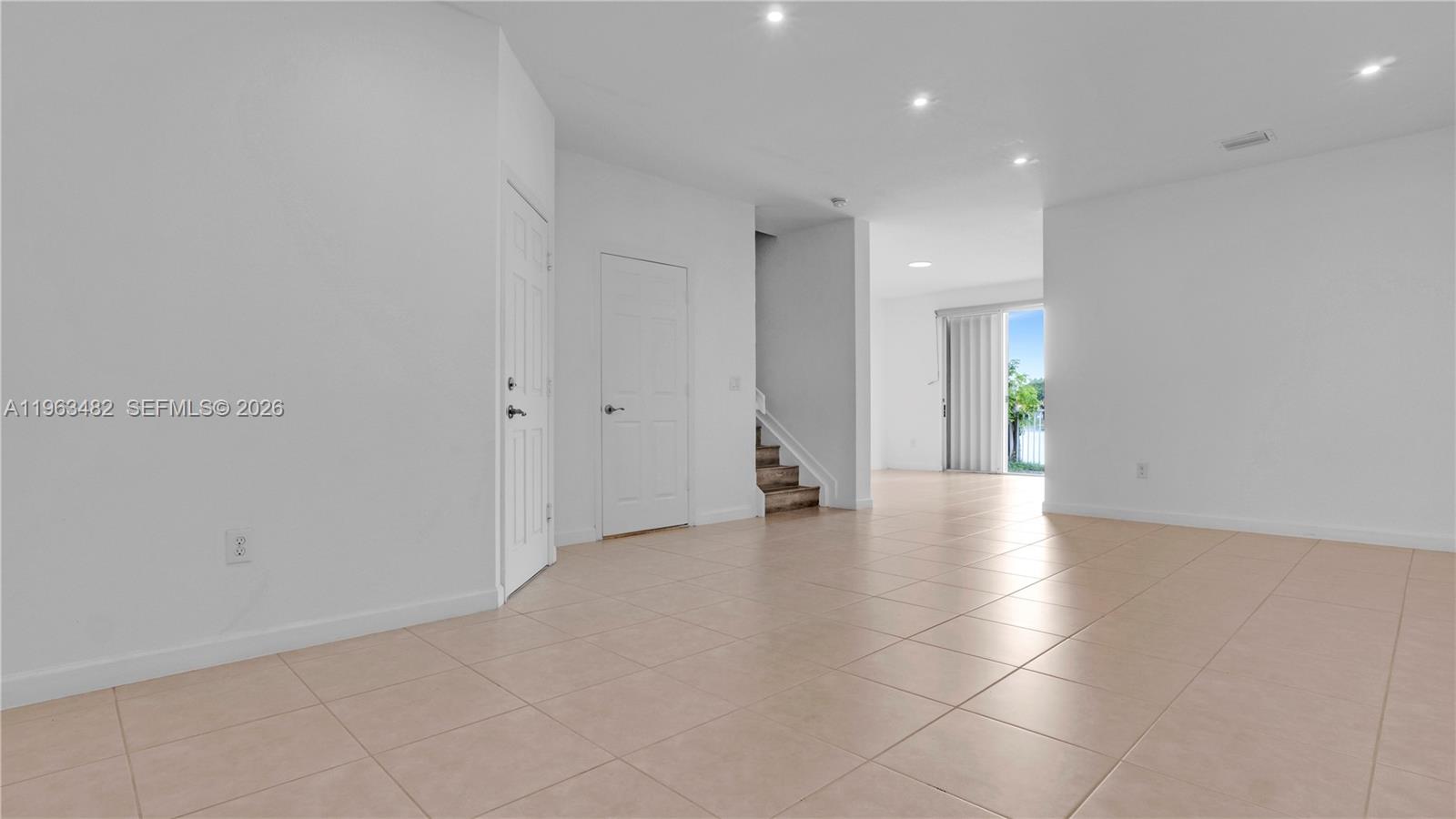 An interior view shows a tiled living area with white walls, recessed lighting, and stairs — 8678 NW 113th Ct, Doral FL 33178, DORAL, FL
