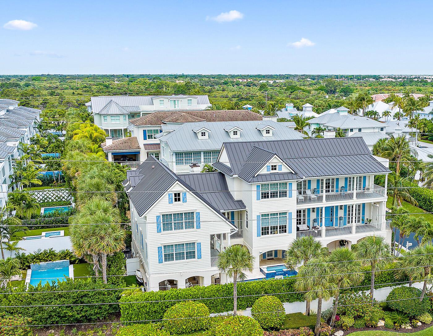 An aerial view of a large white multi-story house with a dark metal roof — 410 Old Towne Lane, Juno Beach FL 33408, JUNO BEACH, FL