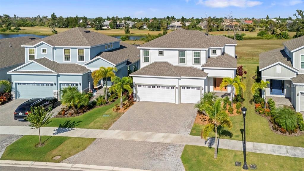 An aerial view shows two suburban houses with paved driveways and manicured lawns — 933 SIGNET DRIVE, APOLLO BEACH, FL