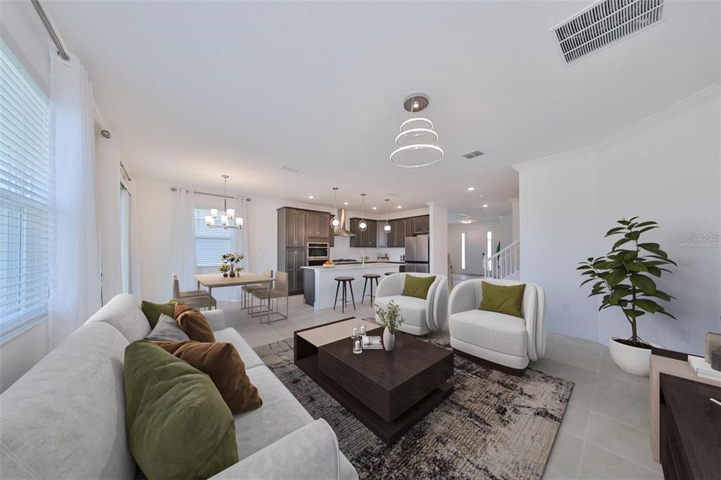 An open-concept living room and kitchen featuring modern furniture, neutral tones, and tile flooring — 933 SIGNET DRIVE, APOLLO BEACH, FL