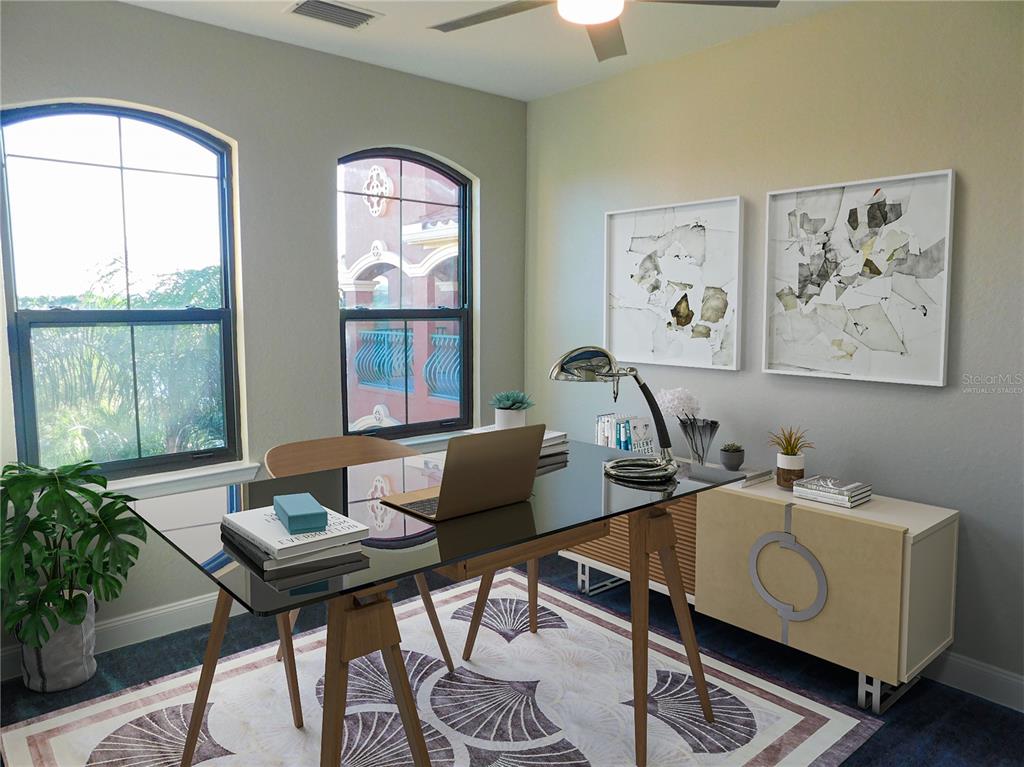 A home office features a glass-topped desk, a patterned rug, and two arched windows — 2725 VIA CIPRIANI UNIT 735B, CLEARWATER, FL