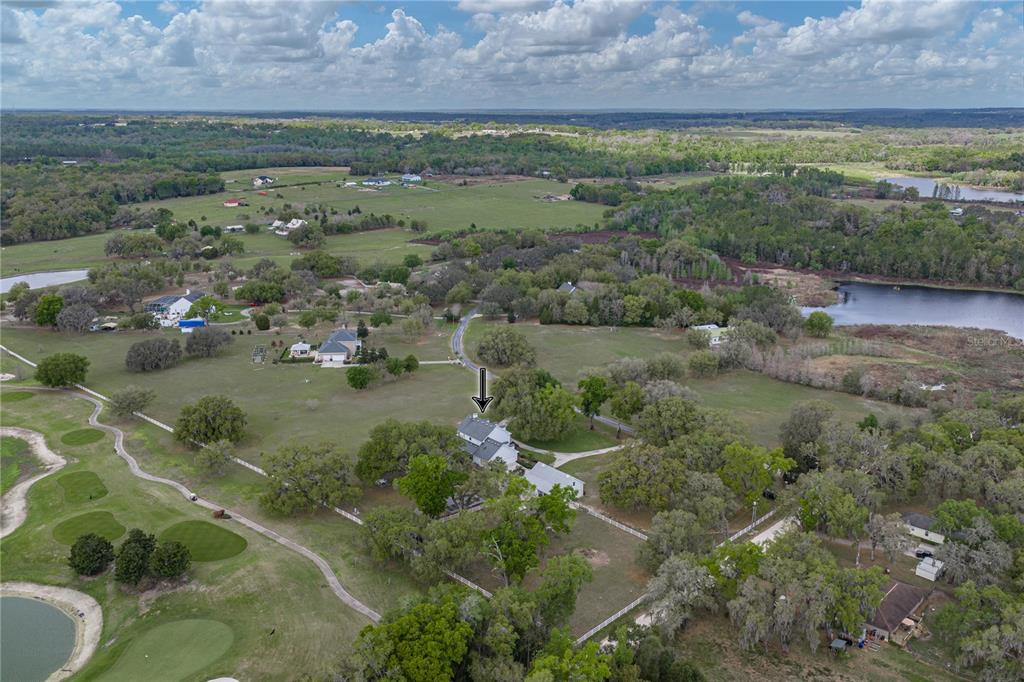 An aerial view shows a house with a white fence surrounded by trees and fields — 34428 MISSION VALLEY DRIVE, DADE CITY, FL