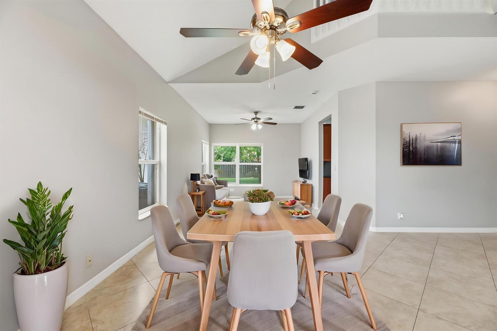 A dining area with a wooden table, six chairs, and a ceiling fan — 7634 Trenton Drive, Lake Worth FL 33467, LAKE WORTH, FL