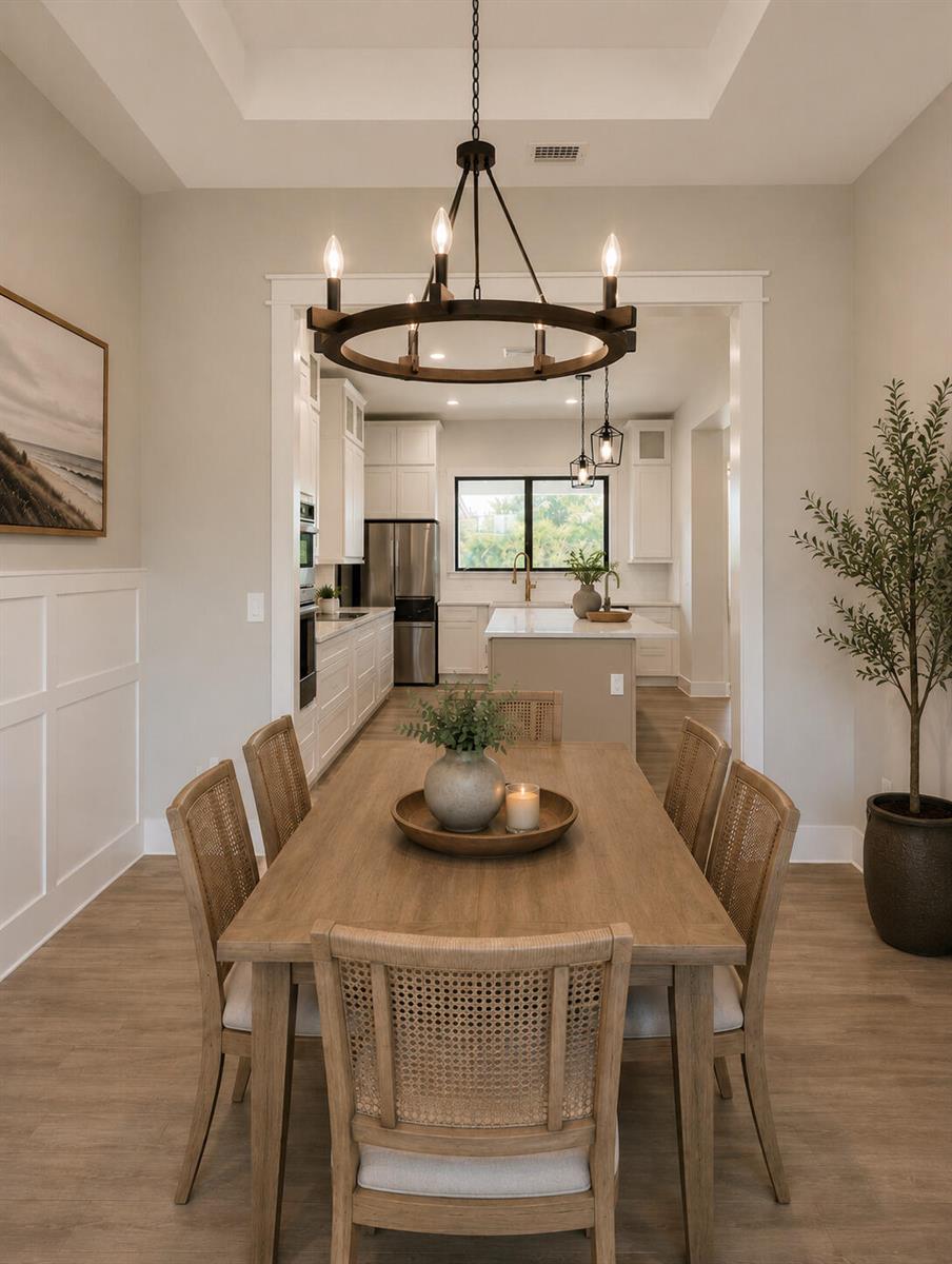 A dining room with a wooden table and chairs leads into a white kitchen — 10603 Lighterwood Lane, Fort Pierce FL 34945, FORT PIERCE, FL