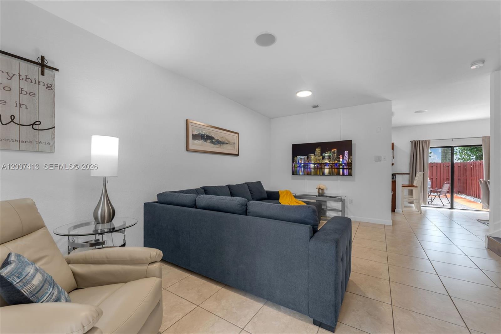 A living room features a blue sectional sofa, a beige armchair, and a wall-mounted television — 15436 SW 119th Ter, Miami FL 33196, MIAMI, FL