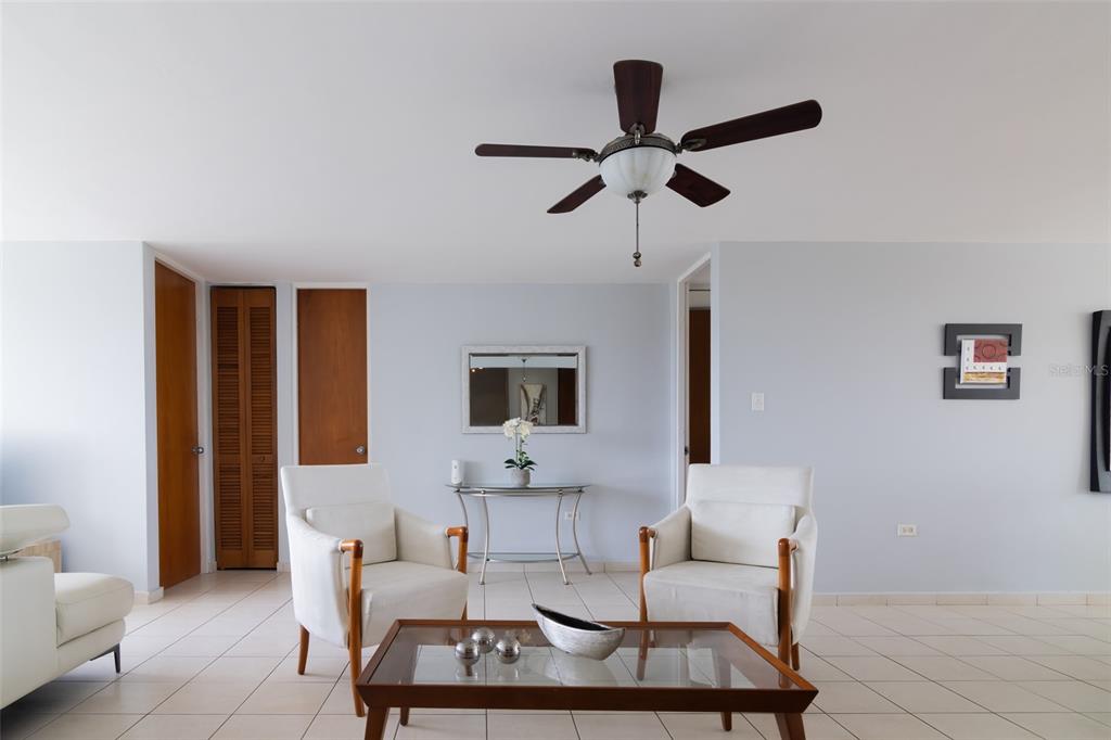 A living room features two white armchairs, a glass coffee table, and a ceiling fan — 9550 CALLE DIAZ WAY | COND. ASTRALIS UNIT 813, CAROLINA, PR