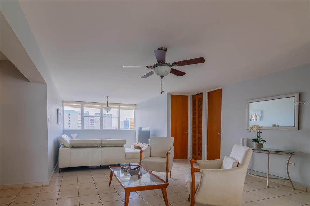 A living room features light-colored tile floors, white furniture, a ceiling fan, and large windows — 9550 CALLE DIAZ WAY | COND. ASTRALIS UNIT 813, CAROLINA, PR