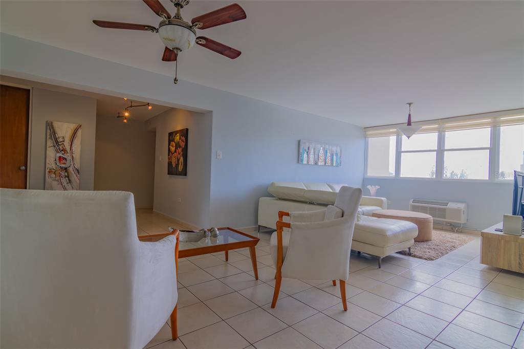 A living room features white tile floors, a ceiling fan, and a white sectional sofa — 9550 CALLE DIAZ WAY | COND. ASTRALIS UNIT 813, CAROLINA, PR
